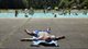 Man relaxing on the side of the Groot Kinderbad, an outside paddling pool for young children in the Amsterdam Forest.